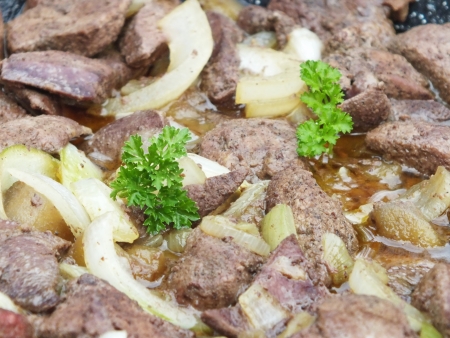 fried liver with apple and onion in a panの写真素材
