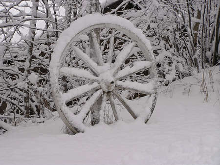 Abandoned wagon wheel in the snow, Quebec, Canadaの写真素材