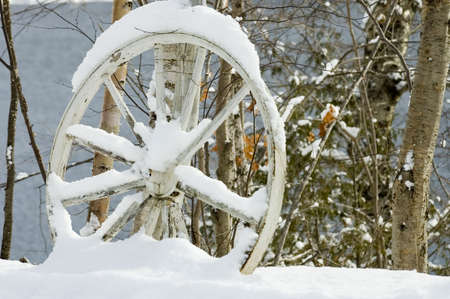 Close up of an abandoned wagon wheel in the snow, Quebec, Canadaの写真素材