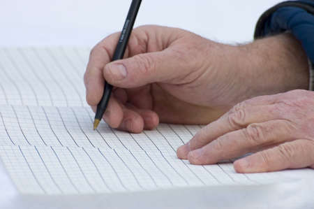 close up of old hands writing dataの写真素材