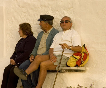 MYCONOS, GREECE - MAY 7TH; Typical Greek seniors with walking stick sit on a bench  7th May 2007 in Myconos, Greeceのeditorial素材