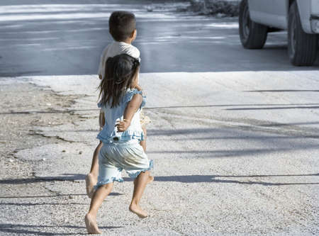 YUCATAN, MEXICO - DECEMBER 14TH;  Bare feet children on street of Yucatan village running for tourists bus,Coba, Mexico, 14th December 2006のeditorial素材