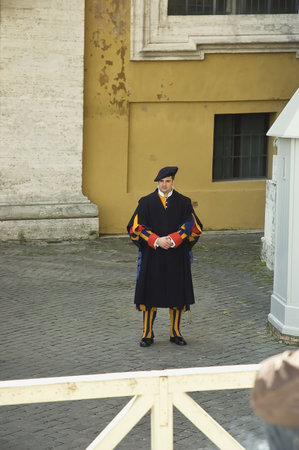 ROME, ITALY - MARCH 26TH; Clourful Swiss guard, Pope bodyguard, standing at the door of Vatican...