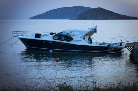Cape Sounion, Athens, Greece - May 6th, 2007 : man abroad anchored boat at sunset in Cape Sounion, Athens, Greeceのeditorial素材