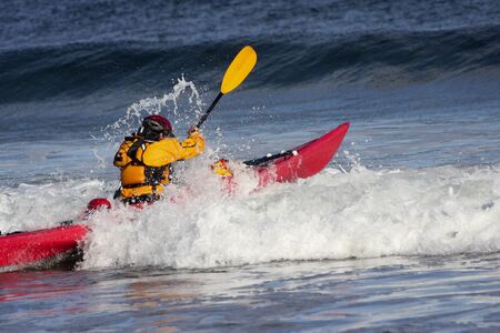 Man fighting the wave on kayak  on rough sea in Black Cove, Nova Scotia coast, Canadaの写真素材