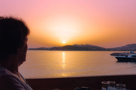 Cape Sounion, Greece - May 6, 2007 : Woman silhouette at sunset in port of Cape Sounion, Greeceのeditorial素材