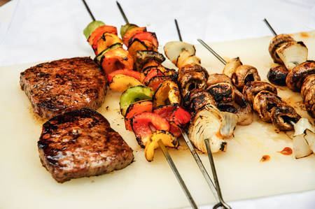 BBQ Steaks and vegetables ready to eat set over a white tableclothの写真素材
