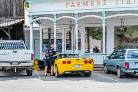 Winthrop, Washington State, USA - June 18, 2006 :  street scene with gentleman and lady coming out the bank and entering  his yellow sports car. Contrasting figure between the past and modern lifeのeditorial素材