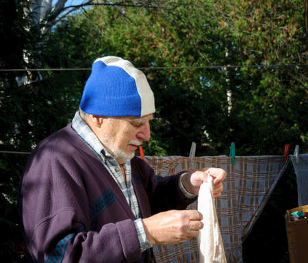 Grandfather putting clothes on the clotheslinesの写真素材