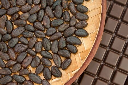 Cocoa beans from Madagascar with chocolate in craft basketの写真素材