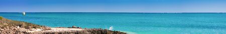 Lagoon panorama with rocks and fishing boat sailingの写真素材