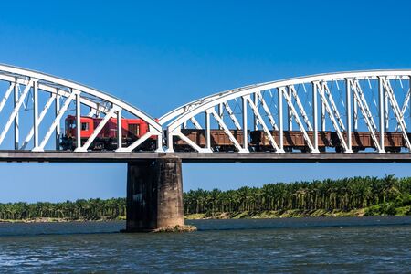 Freight train crossing the river on the bridge in eastern Madagascarの写真素材