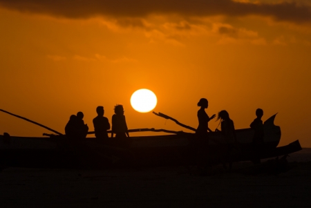 Sunset on a canoe and Malagasy people on oct. 29, 2007 on the Morondava beach, western Madagascarのeditorial素材