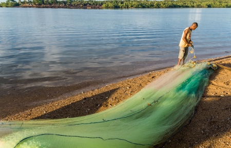 NOSY BE, MADAGASCAR - APR 4: unidentified Malagasy fisherman mending his fishing net on april 4, 2008のeditorial素材