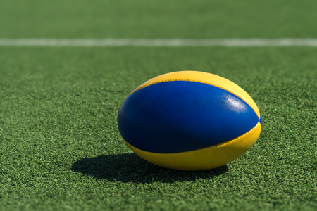 A rugby ball on a synthetic grass in front of the white line.の写真素材