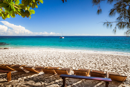 Aligned sun loungers on the beach of Tsarabanjina island, Madaascarの写真素材