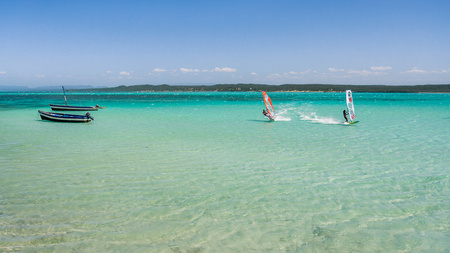 Couple of windsurfers in the vastness of the lagoon of La Mer d'Emeraude, North of Madagascar.の写真素材