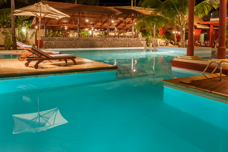 Luxury swimming pool illuminated at nightの写真素材