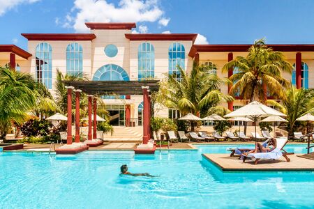 Two girls sunbathing in the luxyry hotel poolの写真素材