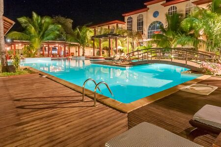 Luxury swimming pool illuminated at nightの写真素材