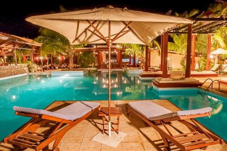 Luxury swimming pool illuminated at nightの写真素材