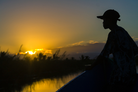 Maroantsetra, Madagascar, April 22, 2017: Malagasy dugout driver watching sunset on the canals of Maroantsetra, East of Madagascarのeditorial素材