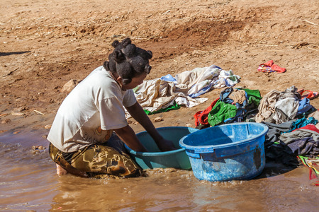 Malagasy woman washnig  clothes on july 3, 2017 in the Tsiribihina river, western Madagascarのeditorial素材