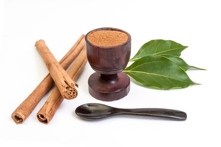 Sticks and powder of cinnamon with leaves isolated on white backroundの写真素材