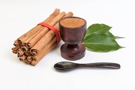 Sticks and powder of cinnamon with leaves isolated on white backroundの写真素材
