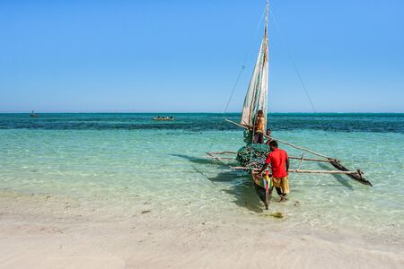 Tsifota, Madagascar,June 09, 2017:  Vezo fishermen and their outrigger canoe on the beach of Tsifota, southwestern Madagascarのeditorial素材