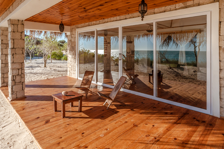 Terrace of a luxurious bungalow with reflection of the sea in the patio doorの写真素材