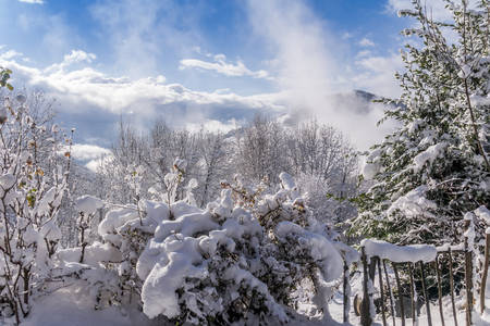Snowy landscape with sun and clouds in the mountains near Grenoble in the French Alpsの写真素材