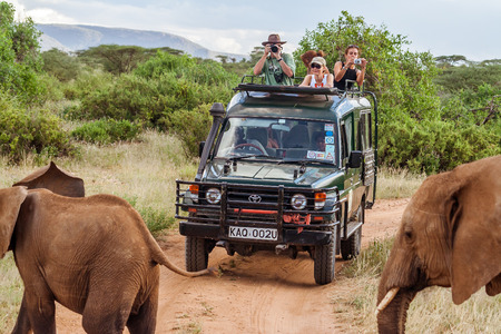Masai Mara, Kenya, May 19, 2017: Tourists in an all-terrain vehicle exploring the African savannah on safari game driveのeditorial素材