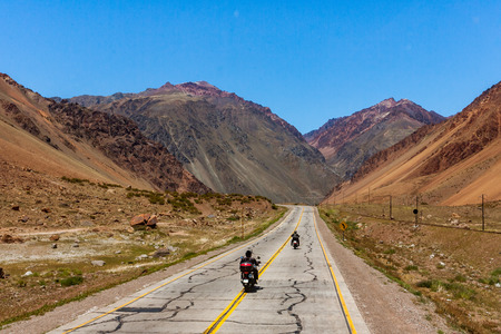 Two bikers on the National Route 7, here in the Andes, crosses Argentina from east to west connecting Buenos Aires to Santiago de Chileの写真素材