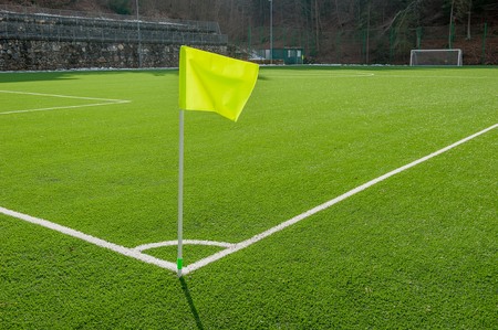 corner in the football field with artificial turf flagの写真素材