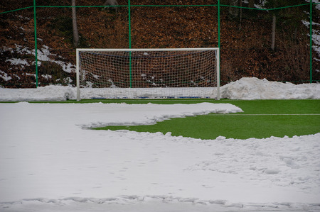 Synthetic soccer field covered with snowの写真素材