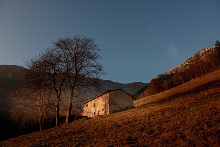 stable in mountain pasture at sunset