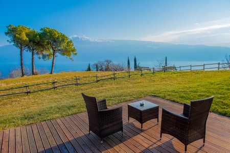 garden furnished with tables, chairs and deckchairs with lake viewの写真素材