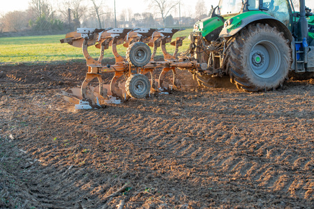 tractor while it is plowing the fieldの写真素材