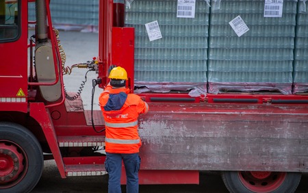 San Pellegrino Italy February 14th 2019: Truck driver secures the loading of bottles of mineral water by binding it with ropes before starting the transportの写真素材