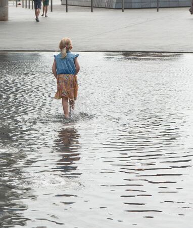 little girl playing with waterの写真素材