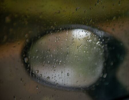 rear view mirror of car wet from drops of waterの写真素材