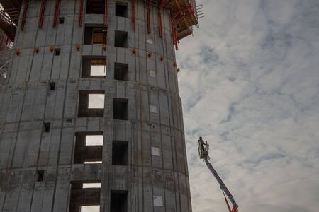 Milan Italy 4 December 2019:worker in safety on a mobile lifting platform in the construction of the...