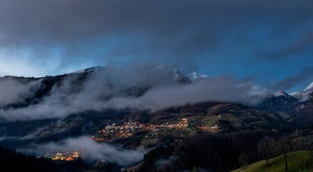 mountain country with clouds after snowfall at sunset