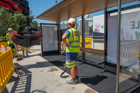 Innsbruck Austria July 27 2020: Workers at work asphalting tram stop with rake and shovelの写真素材