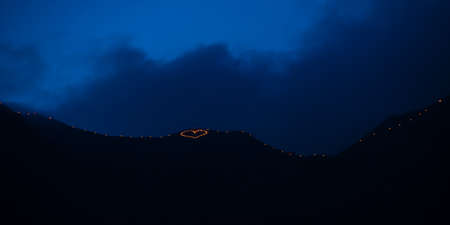 Mountain illuminated with torches that form a heartの写真素材