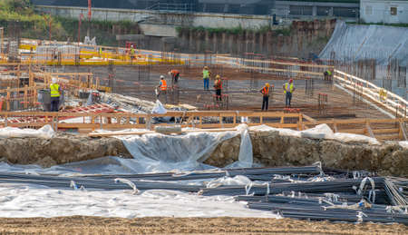 Milan italy september 8 2020: construction workers preparing the base with metal cages to be filled with concrete castingのeditorial素材