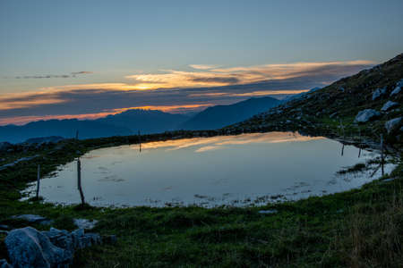 mountain pond reflecting the sunsetの写真素材