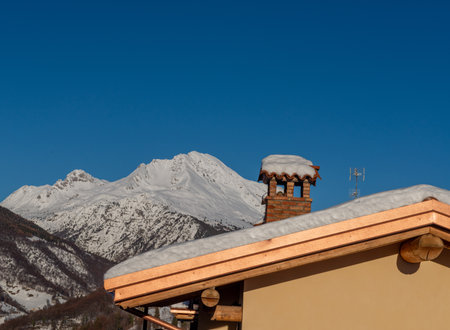 chimney on a snowy roofの写真素材