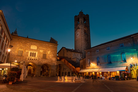 old square with fountain and tower in bergamoの写真素材